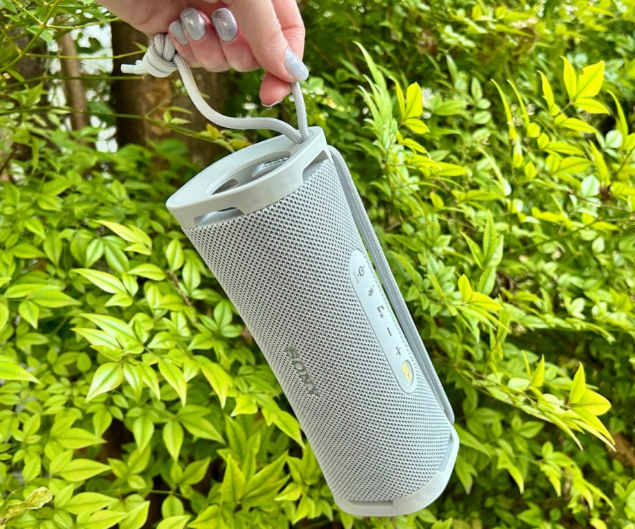 hand holding portable white speaker