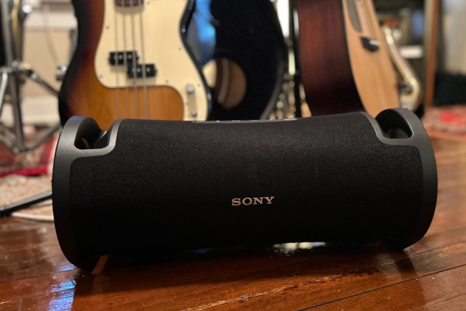 black sony speaker in front of guitars