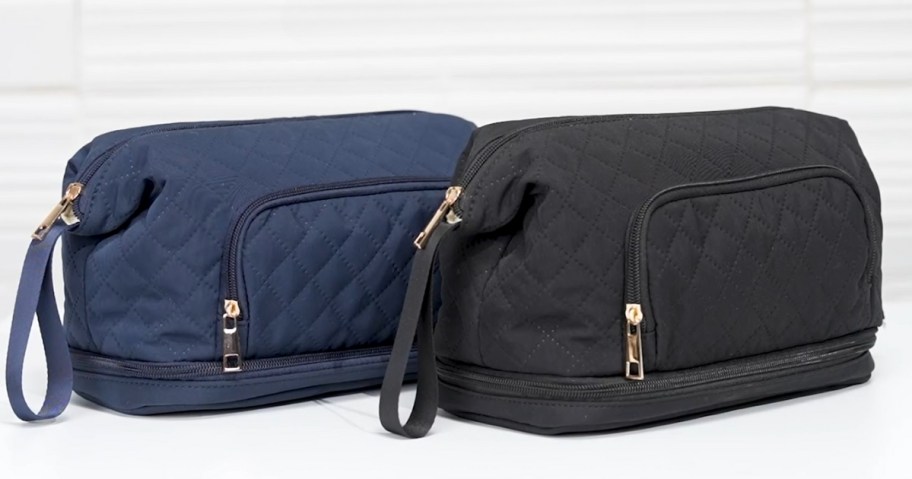 a black and a navy large makeup travel bag on a table