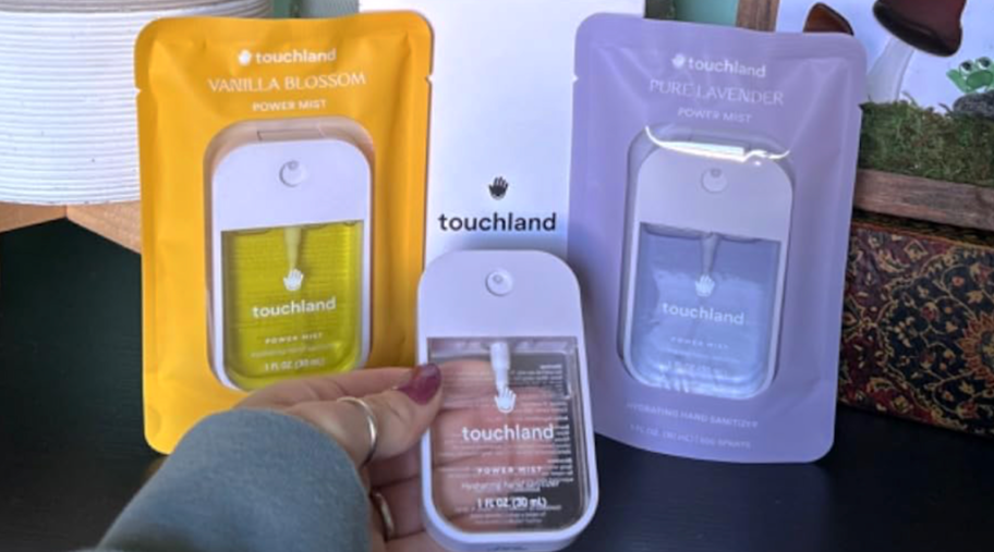 holding a Touchland hand sanitizer