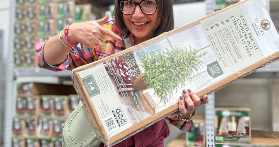 woman holding christmas tree box in store