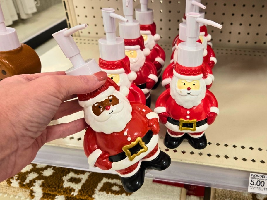 hand on a Santa Clause shaped soap pump on a store shelf