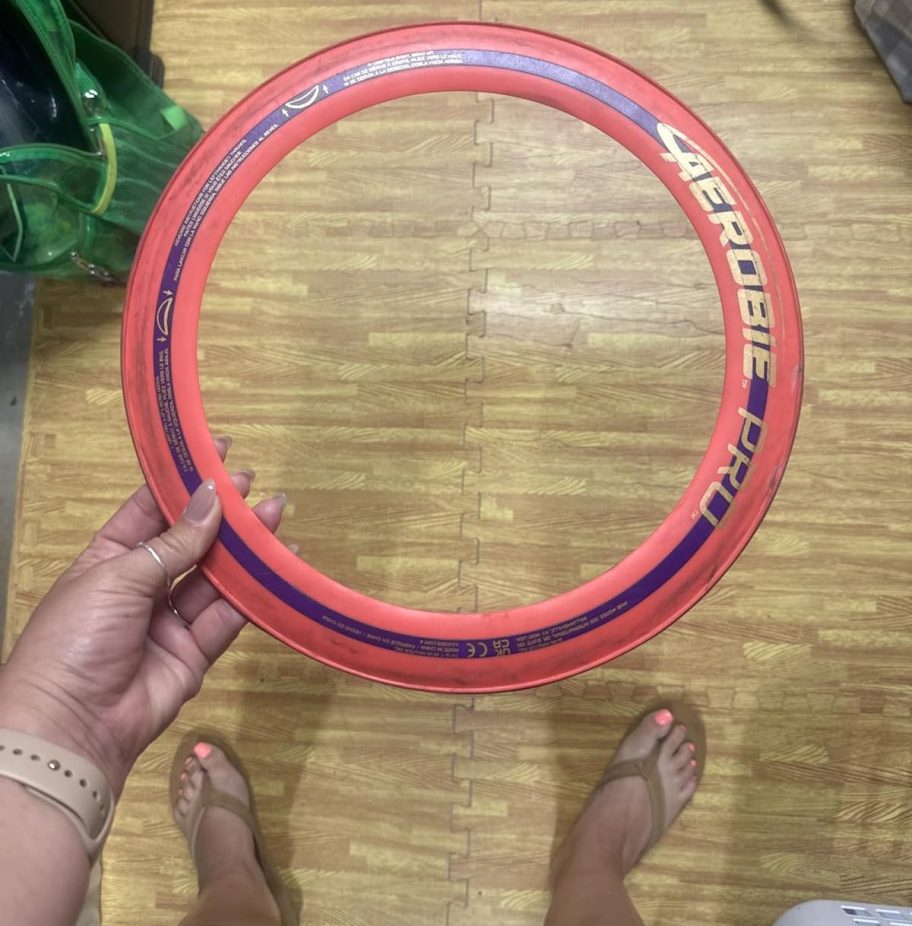 hand holding orange flying disc