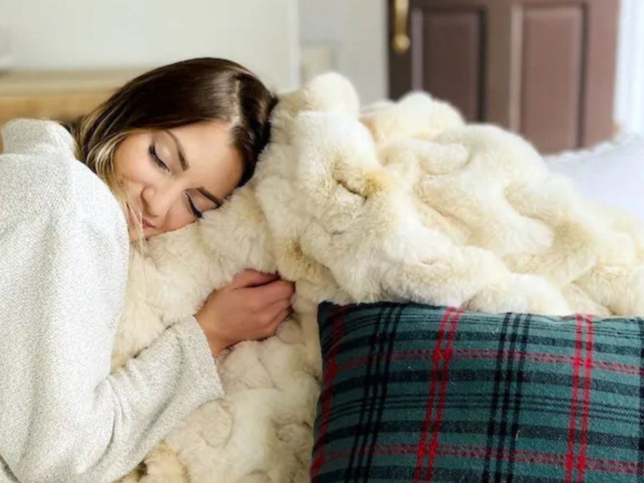 A woman cuddling a soft, fluffy throw