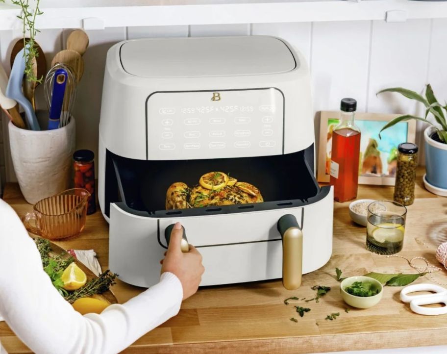 a woman opening an airfryer drawer