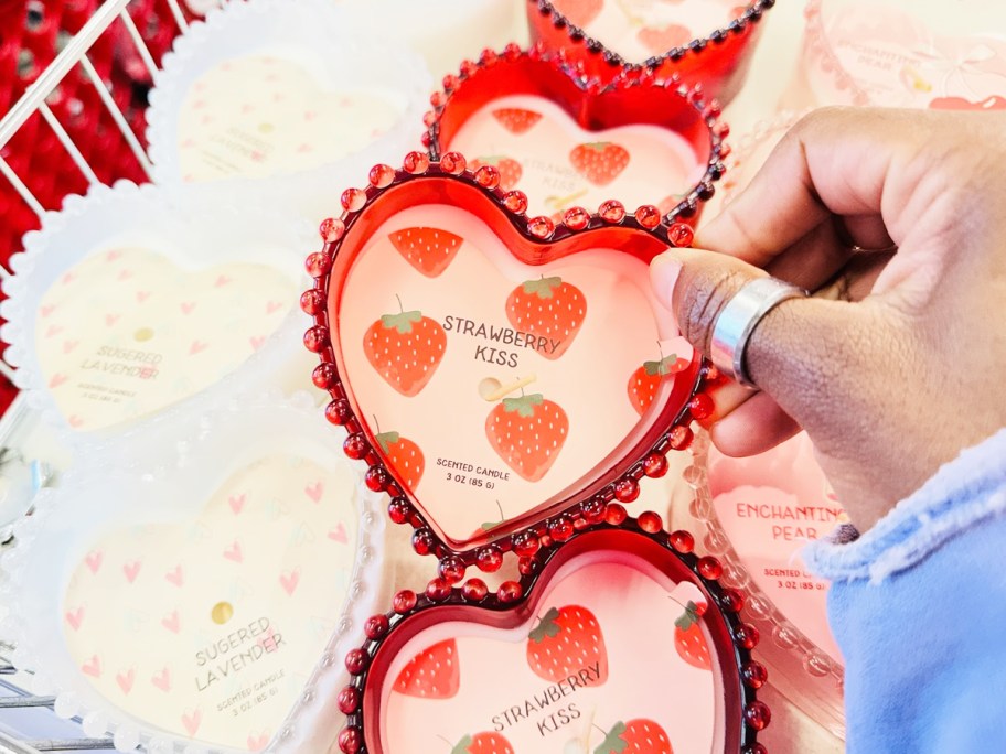 hand touching glass heart shaped candle