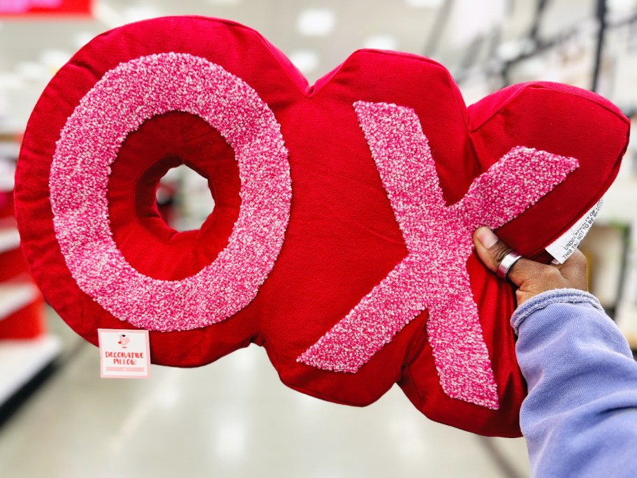 hand holding up a red and pink XO pillow