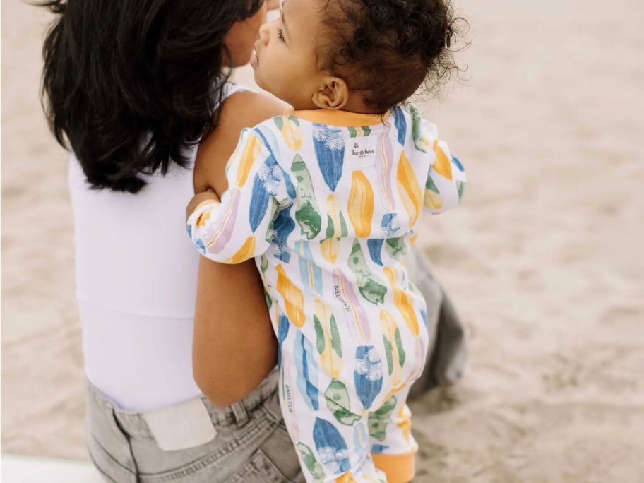 Baby on a beach wearing Burt's Bees Vibrant Surf Organic Cotton Pajamas