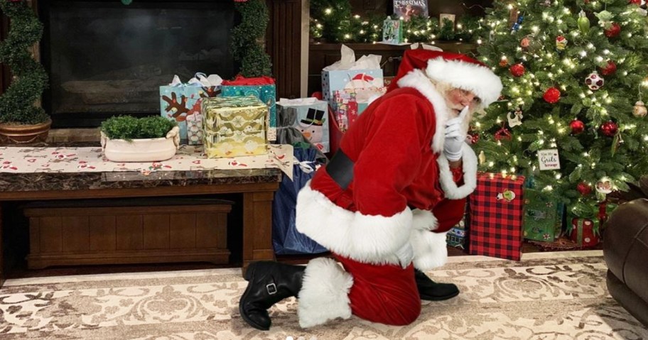 santa in living room near christmas tree