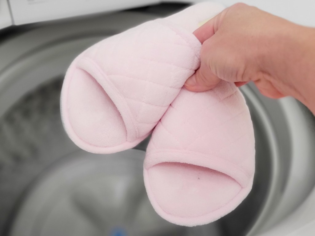 person holding up Dearfoams Women's Beatrice Microfiber Microfiber Terry Slides in front of washing machine