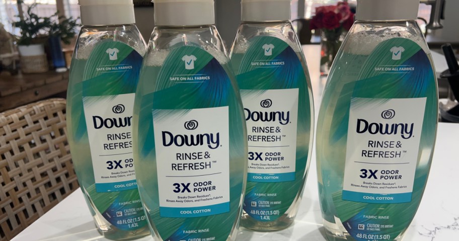 Four bottles of Downy, rinse and refresh in cool cotton on white countertop