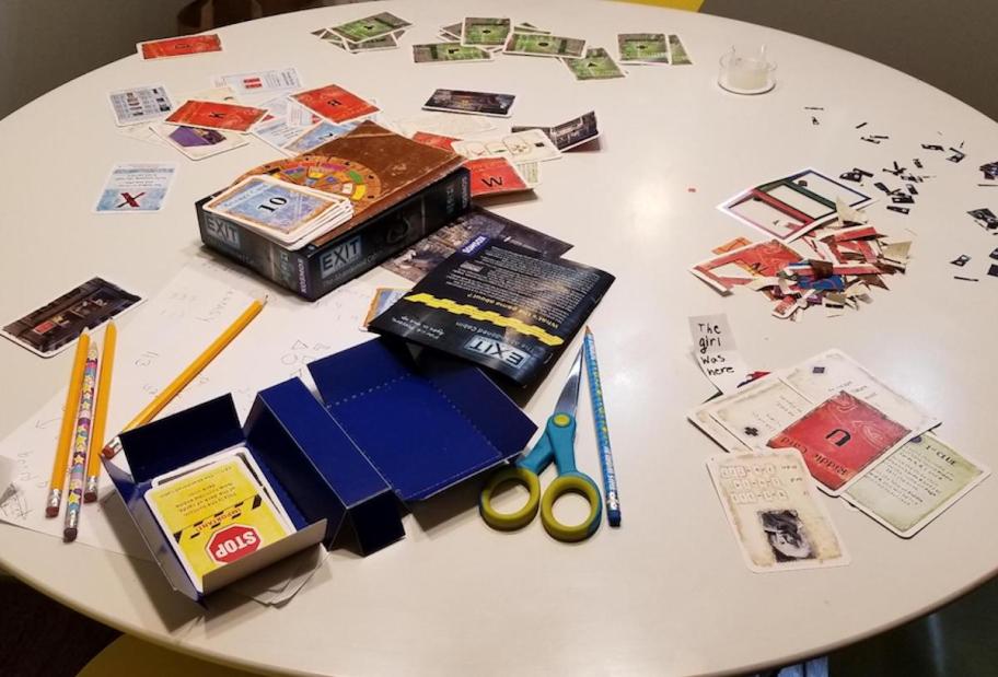 Pieces to escape room game laying on round table 