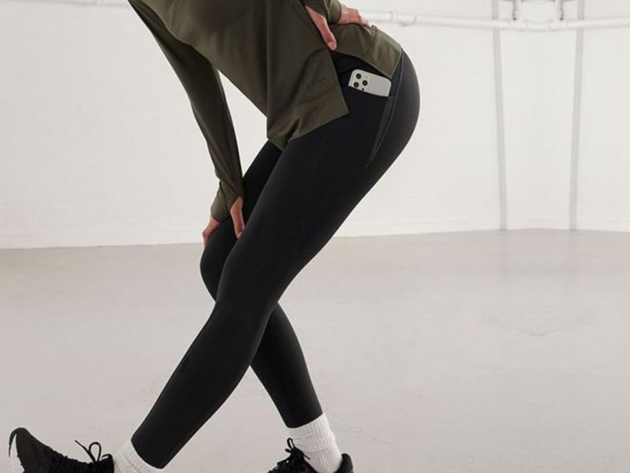 Woman stretching while wearing Gayhay leggings