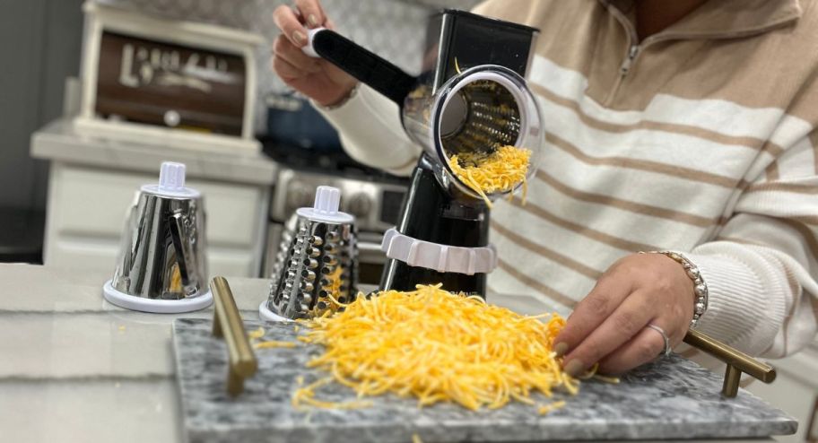 Woman using grater with sharp cheddar 