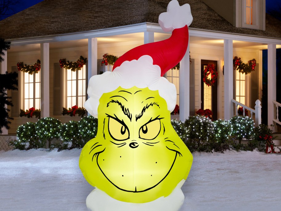 grinch head with santa hat inflatable in yard