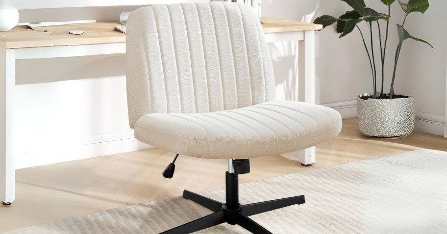a white office chair with a wide seat and back, desk behind it