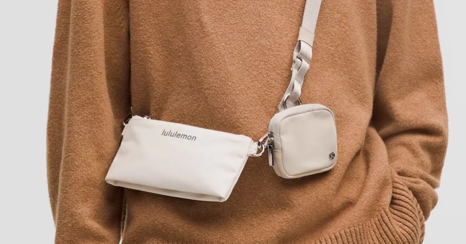 person wearing a tannish gold sweater with a beige color lululemon dual pouch crossbody bag set