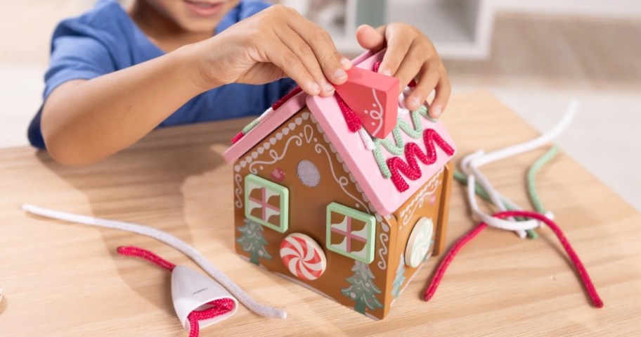 kid putting together a play Gingerbread House