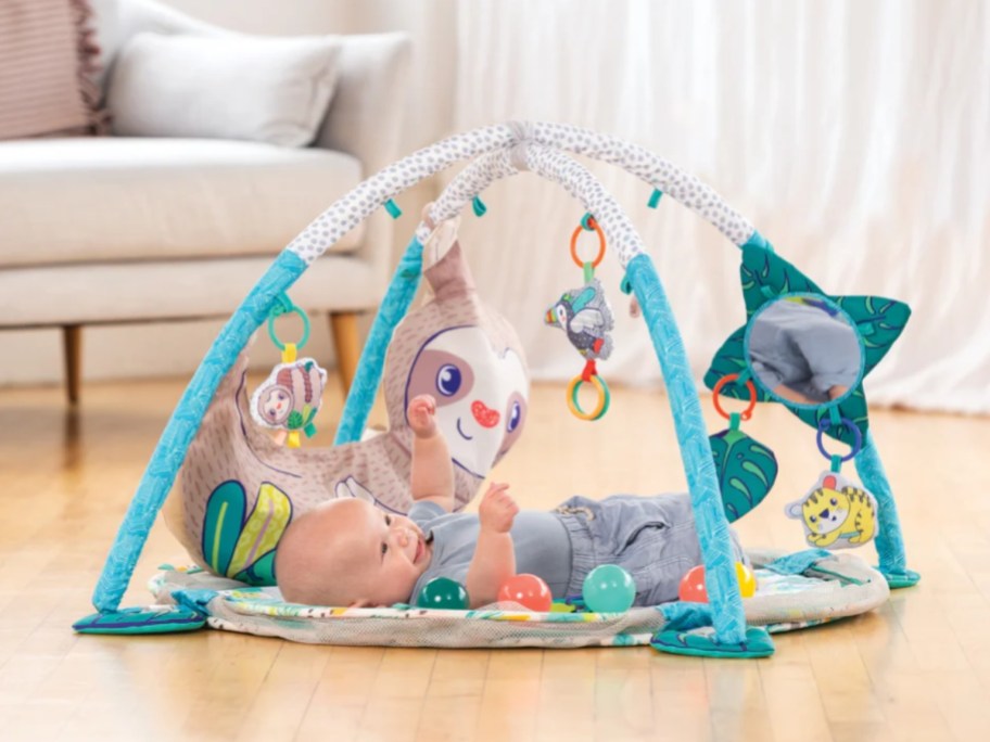 a baby laying on an activity gym playmat