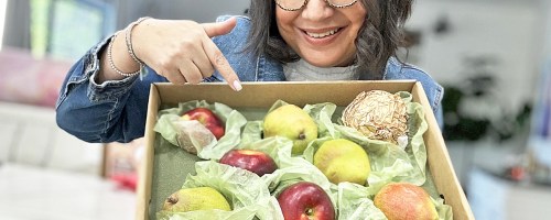 woman holding up and pointing to a Harry & David Pears & Apples Gift Box