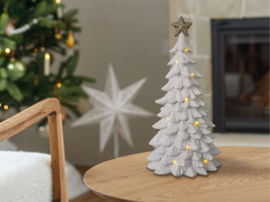 A white light-up tree on a table 