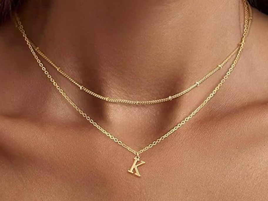 A woman wearing a gold "K" initial necklace