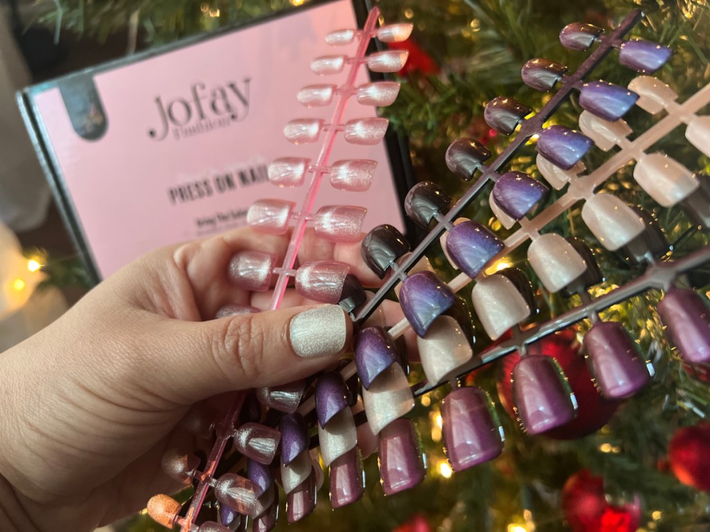 Woman holding up set of jofay artificial nails