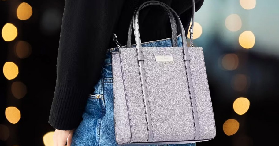 woman in a black sweater with a small silver glittery crossbody tote bag