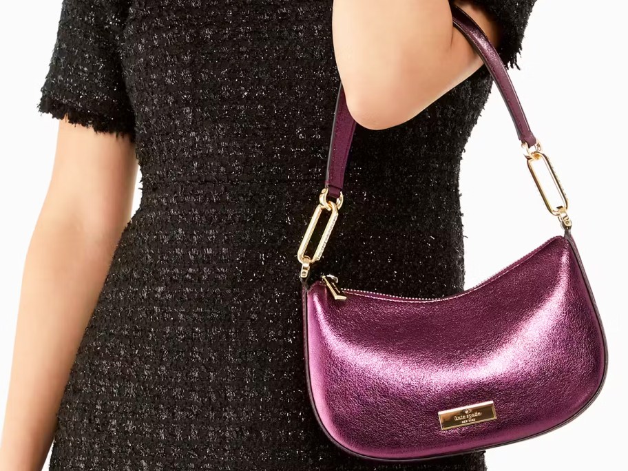 woman in a black dress with a purple metallic shoulder bag