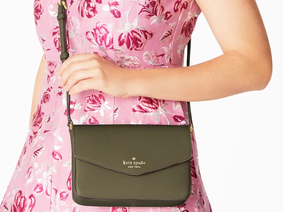 woman in a pink dress with an olive green crossbody bag