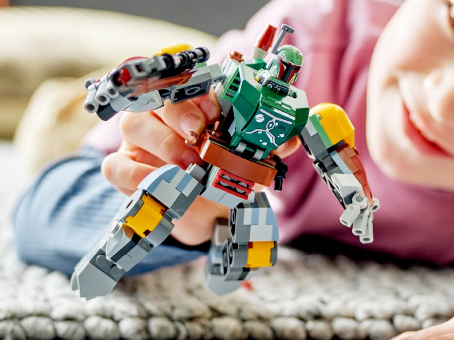 boy playing with LEGO Star Wars Boba Fett Mech Action Figure