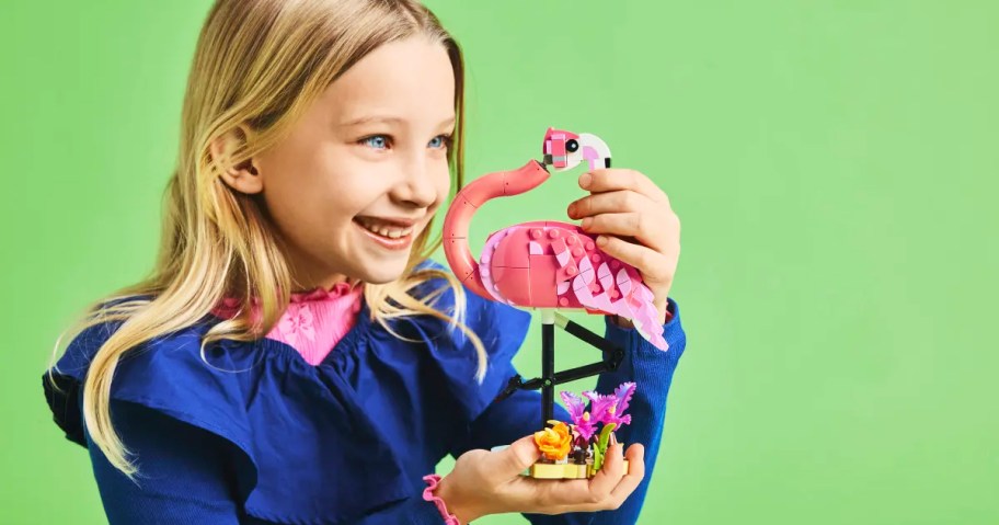 girl holding a Pink Flamingo lego set