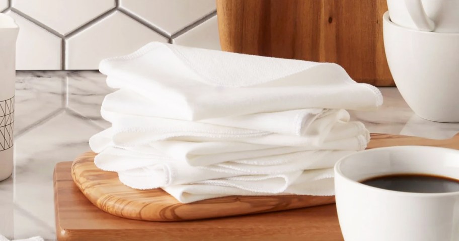 white dishcloths stacked on cutting board