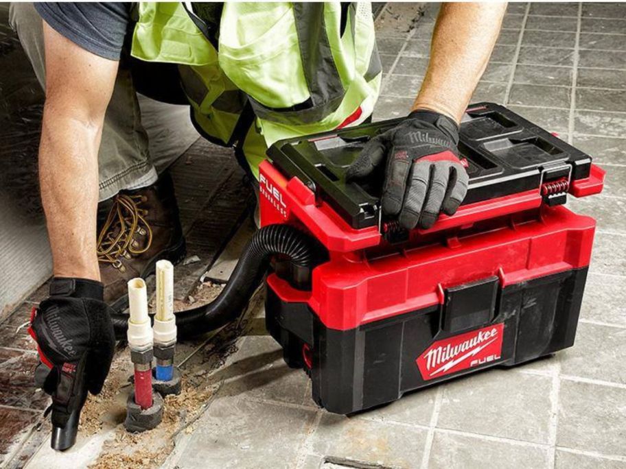 Man using Milwaukee M18 Fuel Packout Cordless 2.5-Gallon Wet/Dry Vacuum w/ 5Ah Battery