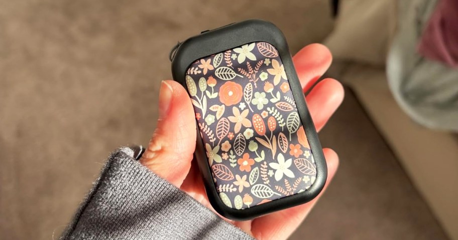 hand holding a floral print hand warmer