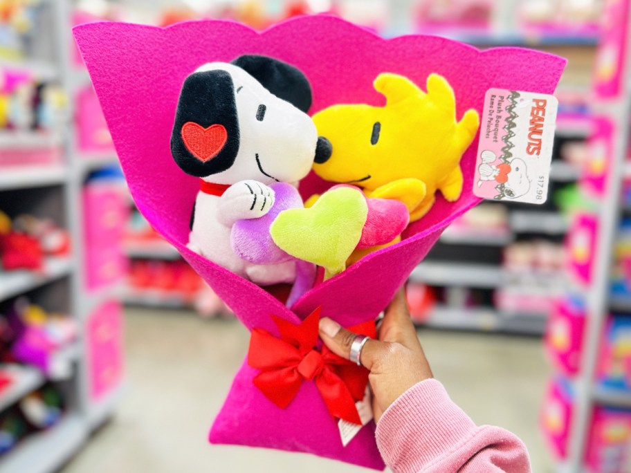 hand holding up Peanuts 5-Piece Plush Valentine's Bouquet in store