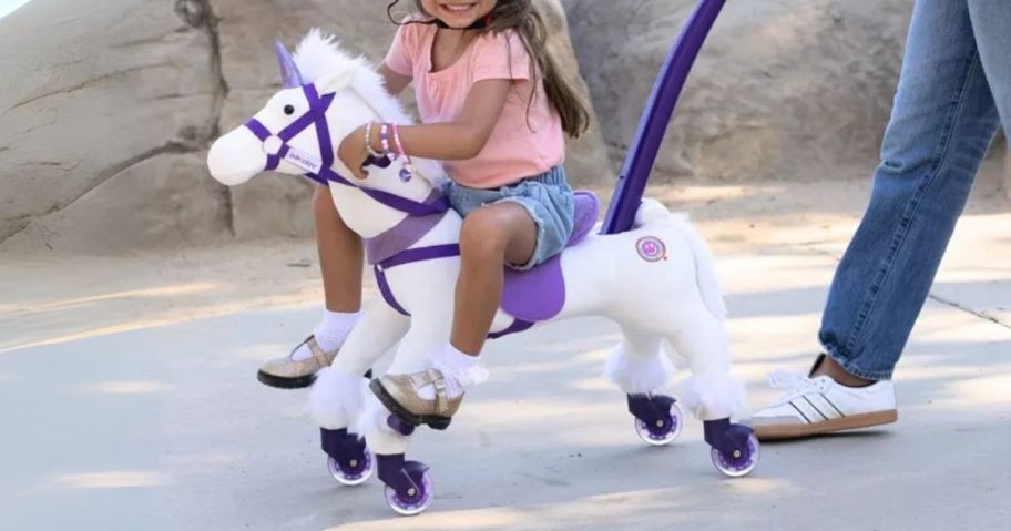 girl riding on Power Pony Push Riding Toy - Crystal with woman pushing it