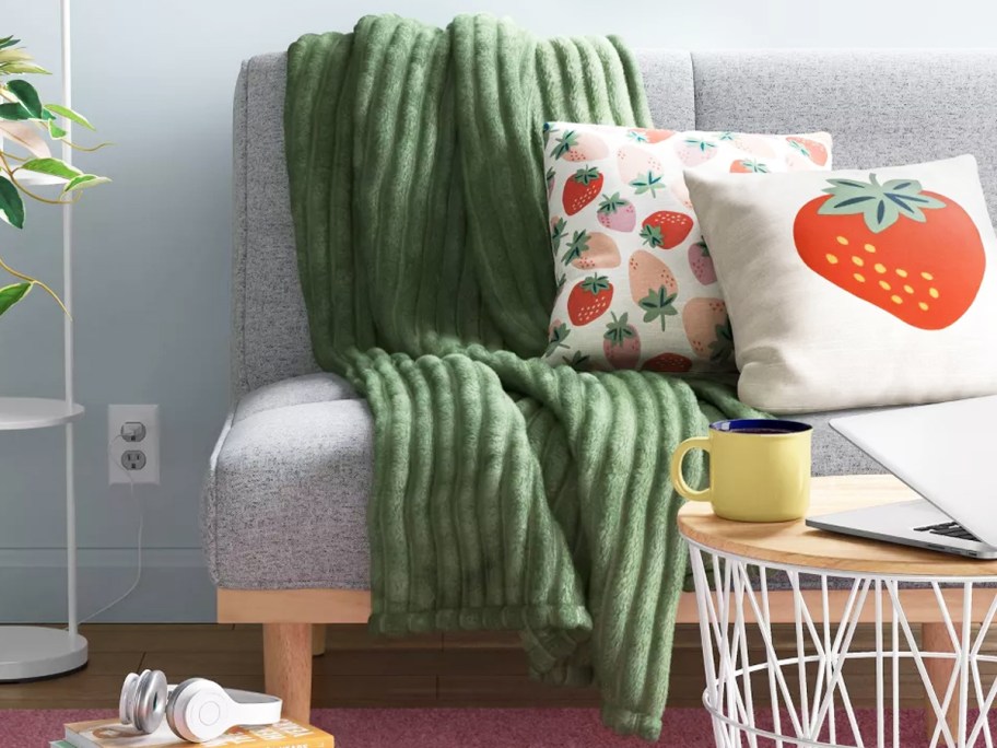 green ribbed throw blanket draped over couch