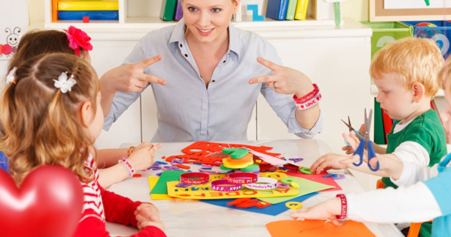 Kids and teacher talking and wearing Valentine's Day rubber bracelets