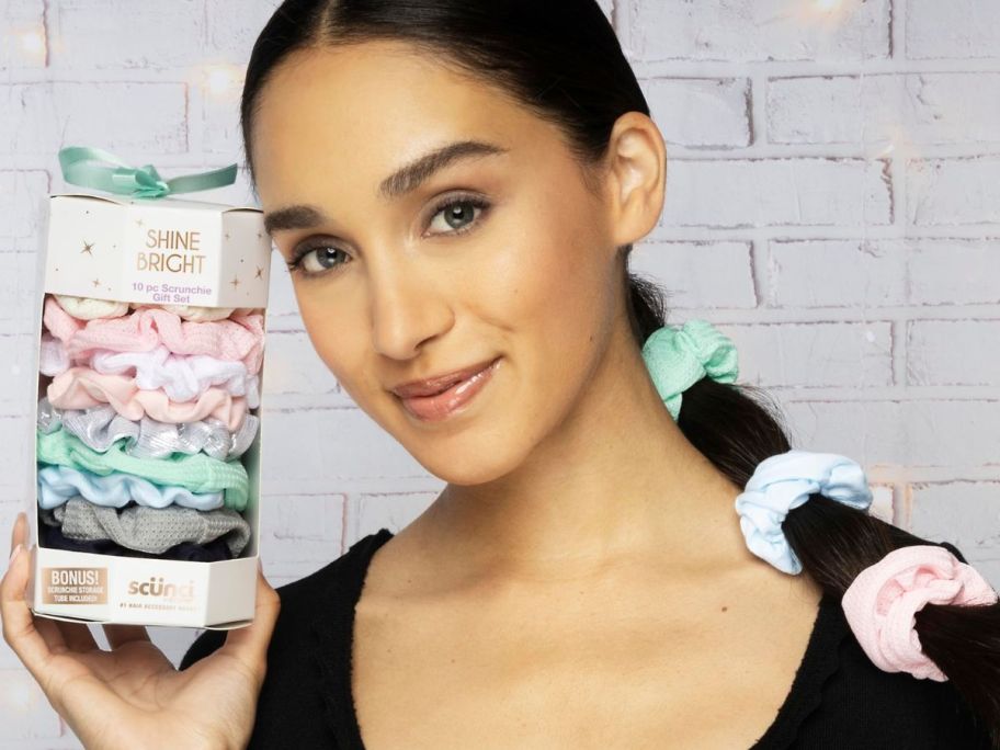 woman holding a 10-pack of holiday Scunci scrunchies