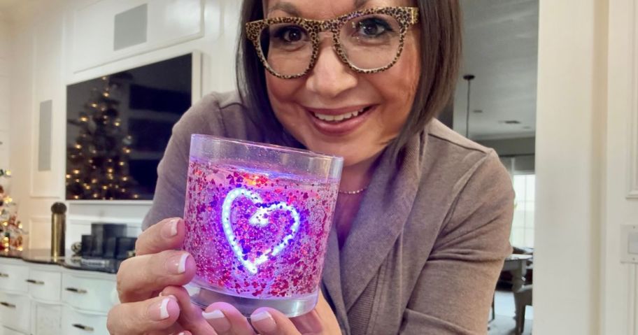 Woman holding a Valentine's Day Glitter LED Candle from Target