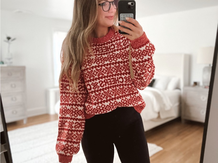 woman taking a selfie wearing a CHEERS Christmas sweater 