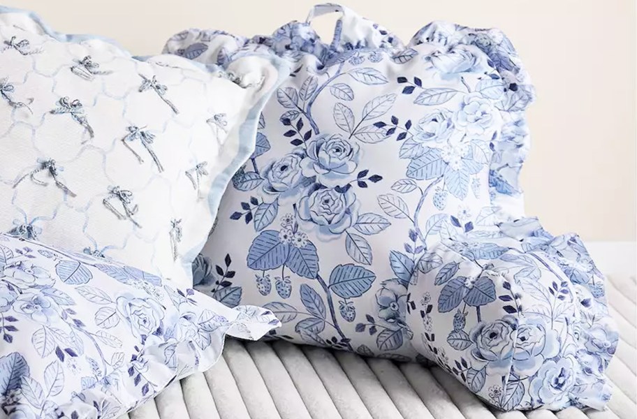 blue floral print backrest pillow with ruffles near other throw pillows