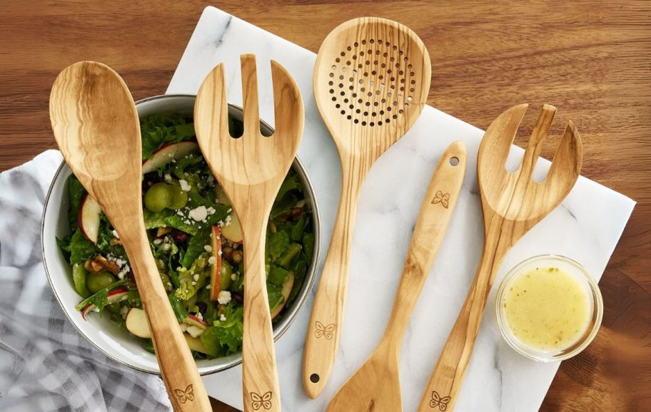 a 5 piece wooden kitchen utensil set arranged on a wooden counter top 