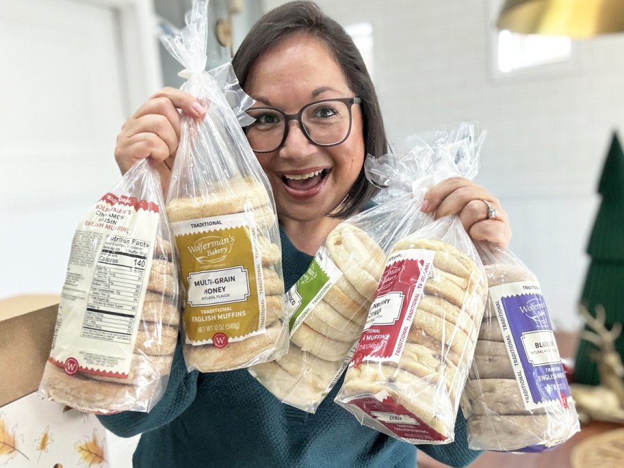 woman holding up multiple bags of english muffins