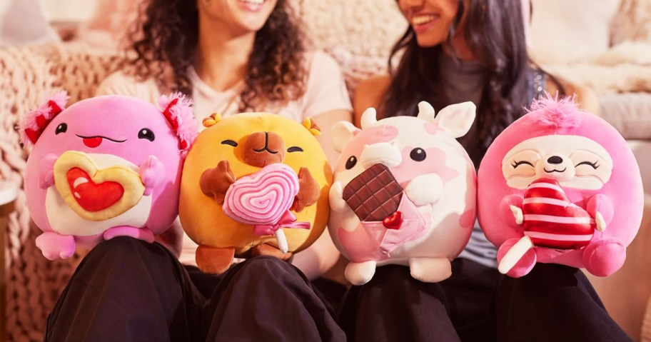 two girls holding up four ZURU Snackles Valentine's Day Plushes