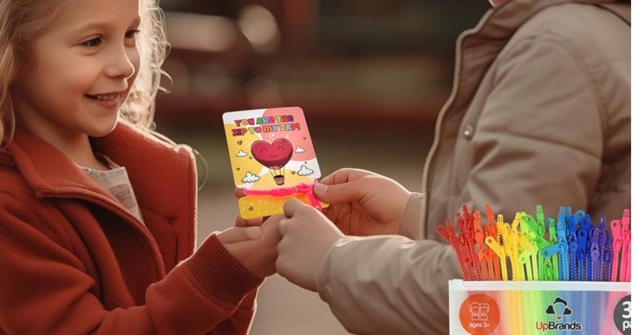 Young girl and boy, exchanging zipper bracelet Valentine's Day cards