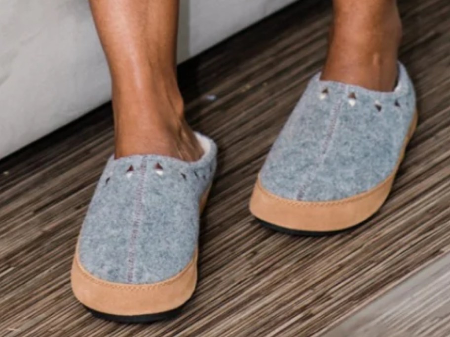 women's feet and legs wearing a pair of grey clog slippers