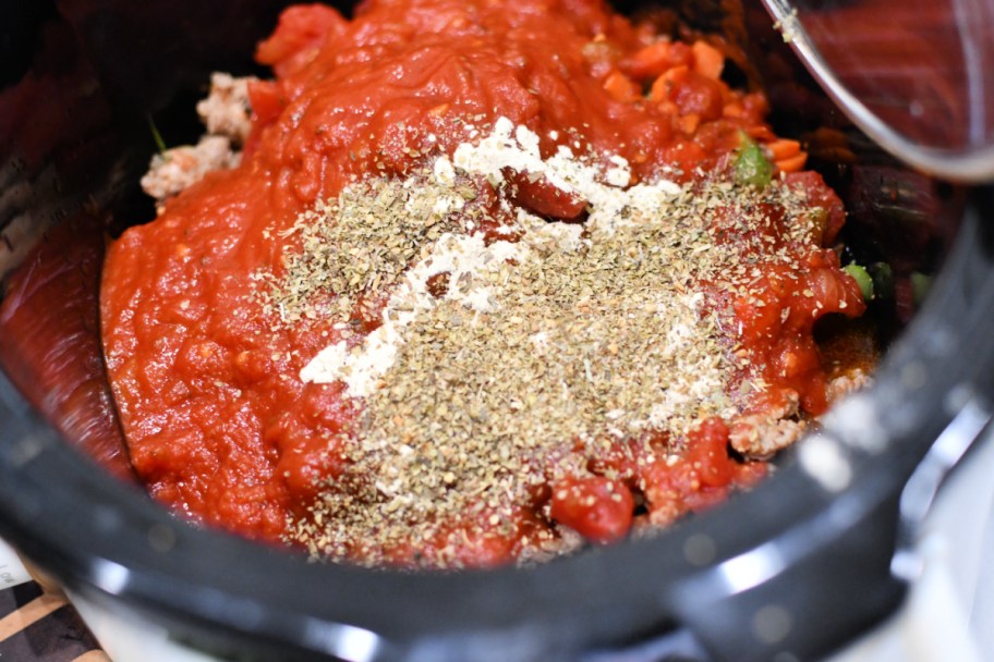 adding seasonings to italian sausage soup