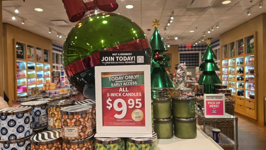 candle day sign surrounded by 3 wick candles in bath and body works stores